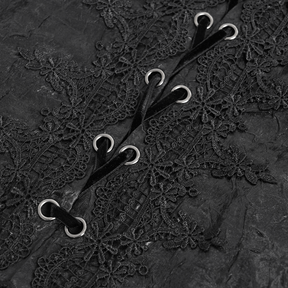 Close-up of intricate lace detailing and black lace-up fastenings on a gothic men's shirt, emphasizing dark elegance.