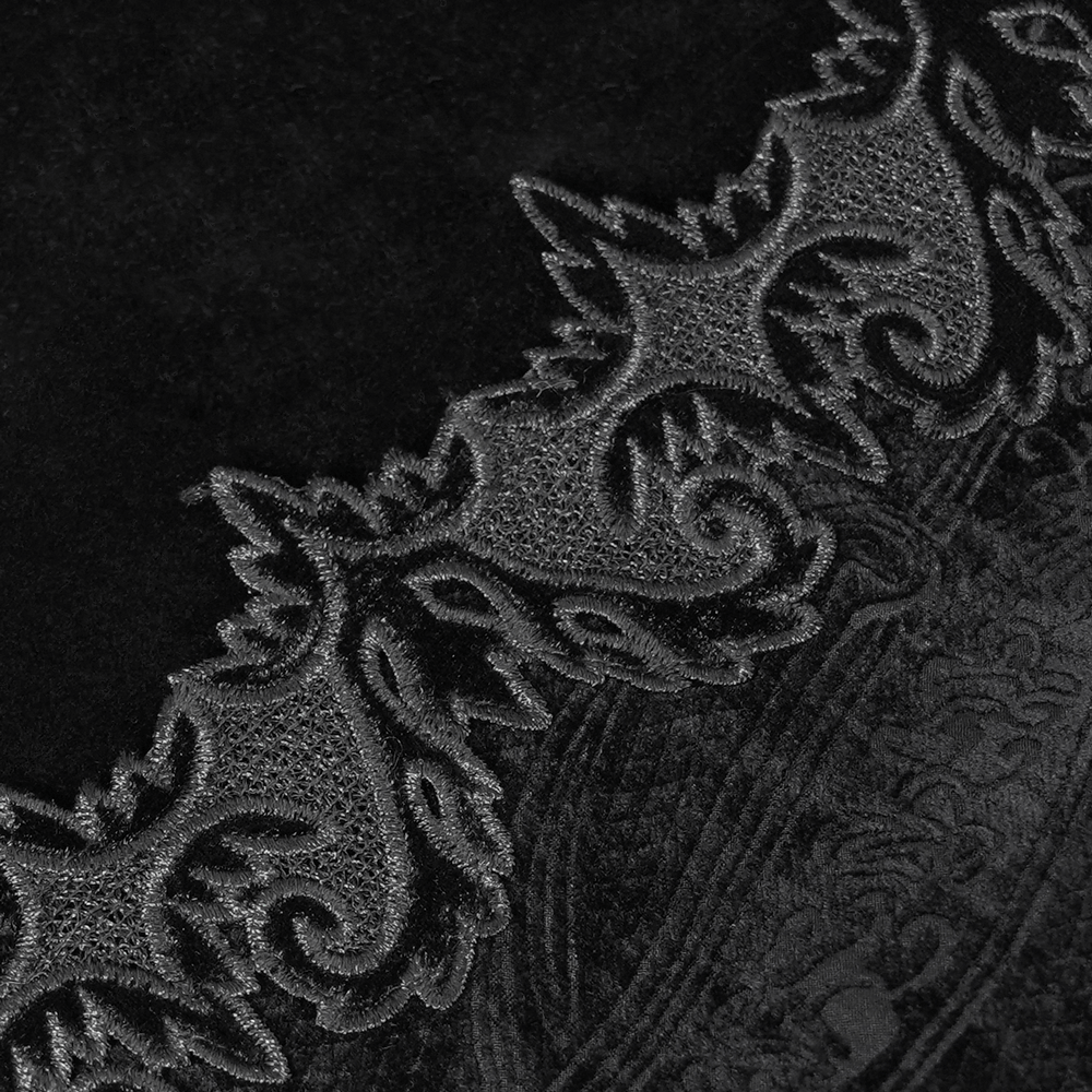 Close-up of intricate brocade trim on black velvet fabric, showcasing gothic design details.