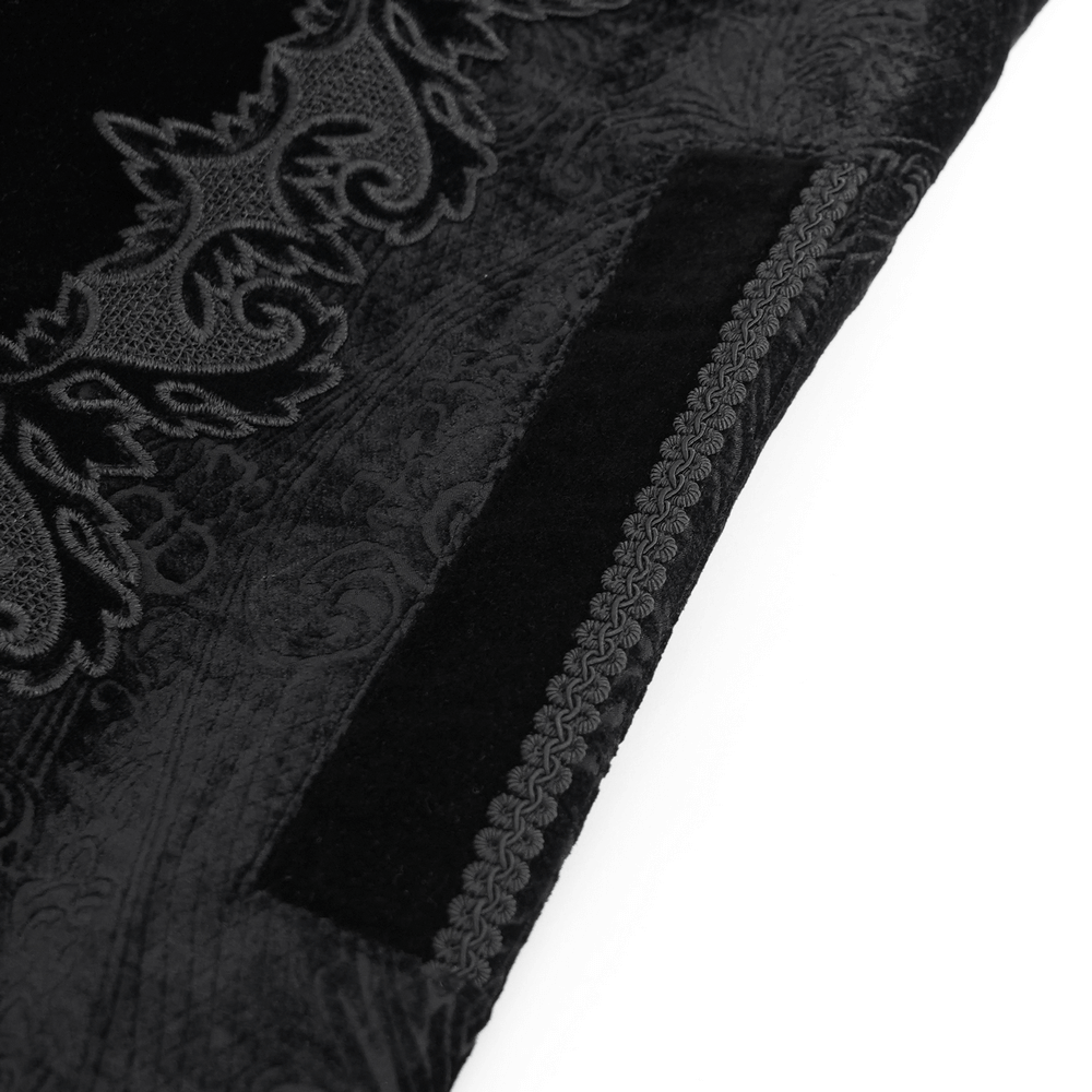 Close-up of the rich black velvet and intricate brocade trim on a men's gothic long coat.