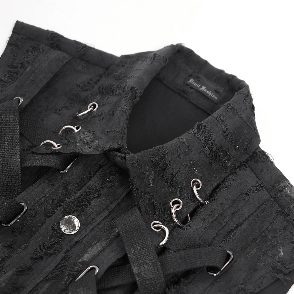 Close-up of men's gothic punk sleeveless shirt featuring laces, metal rings, and rugged textured fabric.