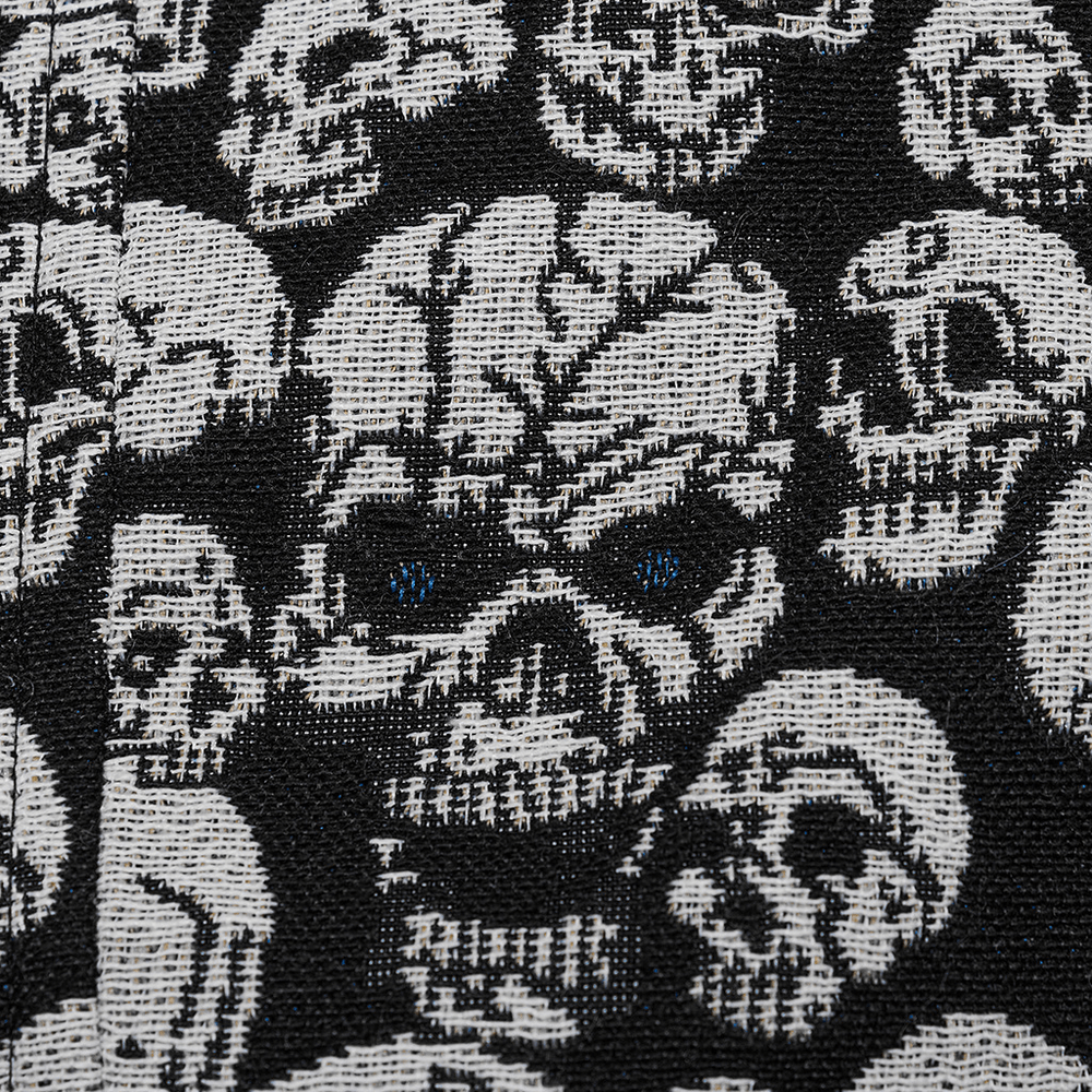 Close-up of gothic skull jacquard fabric featuring intricate skull designs in black and white.