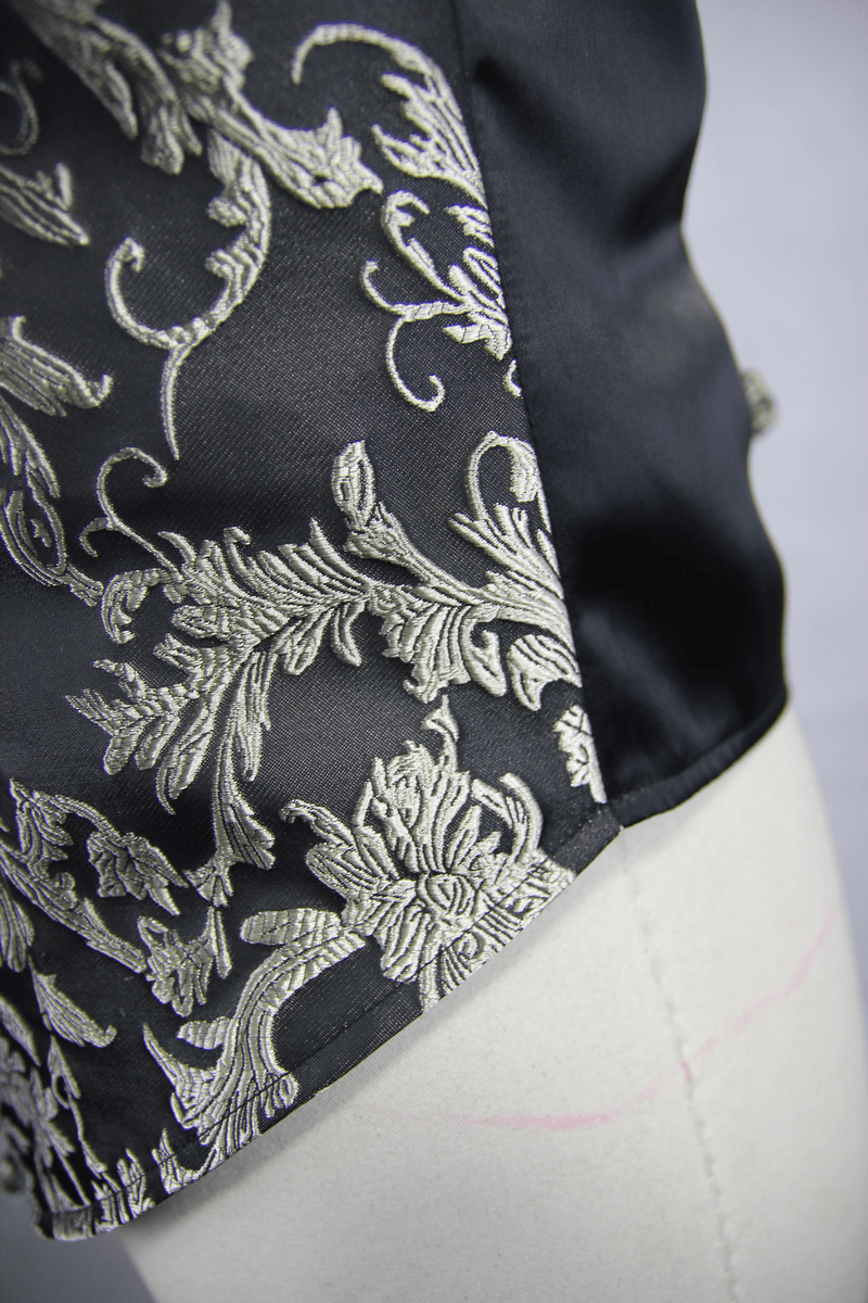 Close-up of the luxurious embroidered fabric on a gothic men's waistcoat, showcasing intricate silver floral patterns.