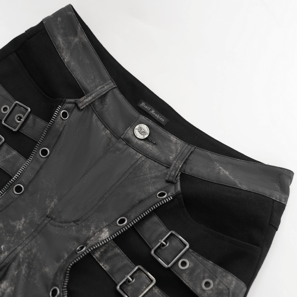 Close-up of men's gothic techwear pants featuring buckles, rivets, and distressed faux leather panels.