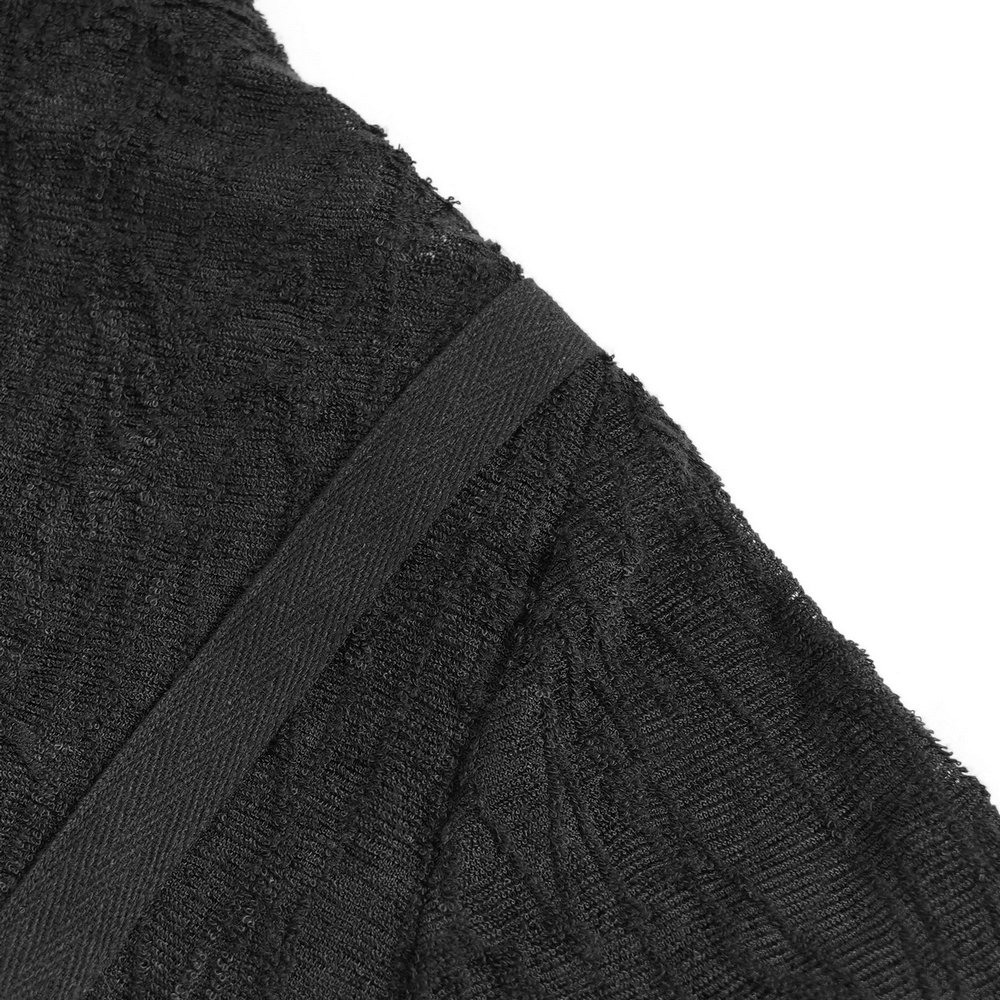 Close-up of adjustable strap on a black gothic mesh top with a textured fabric.