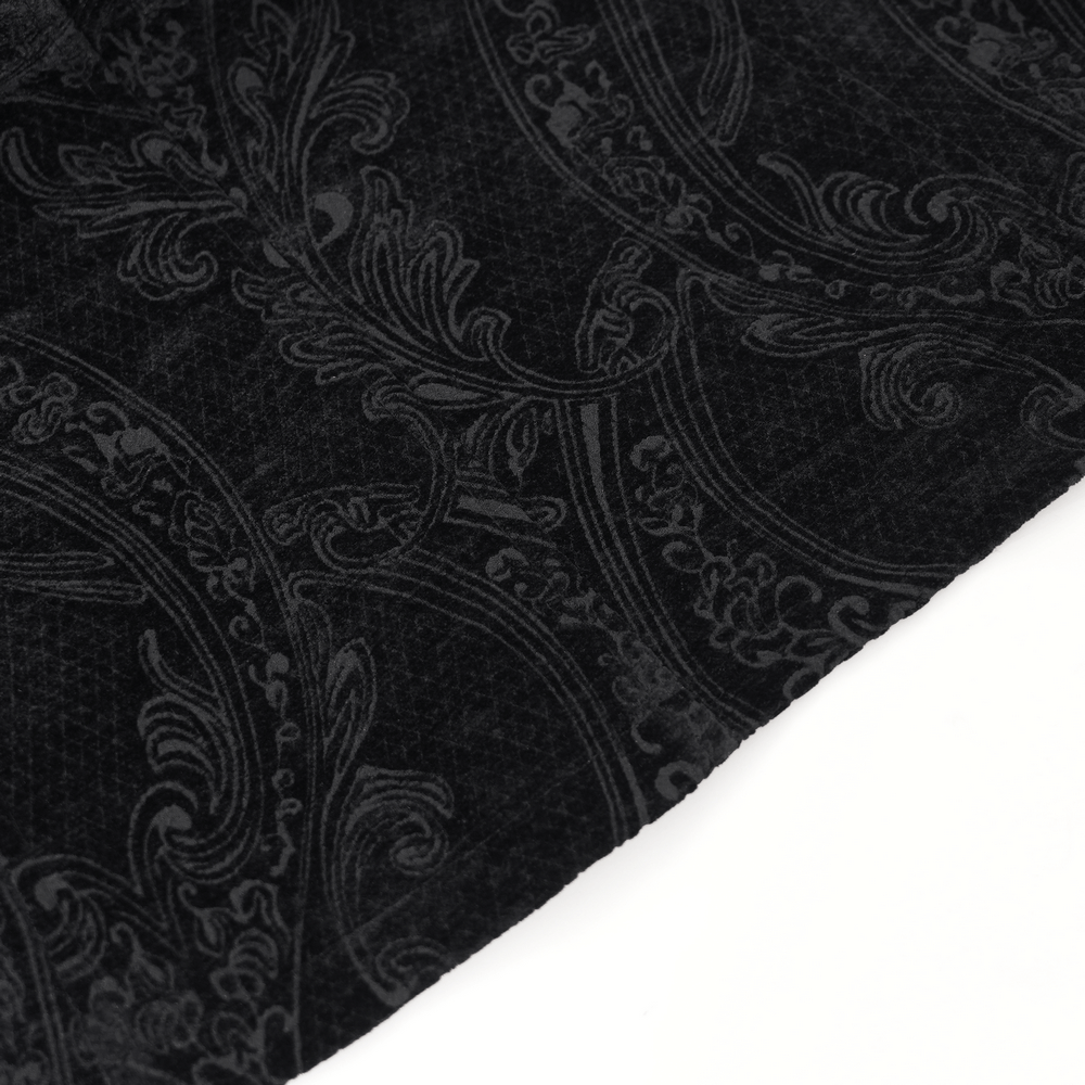 Close-up of intricate black brocade fabric with elegant floral patterns, showcasing vintage Gothic style details.