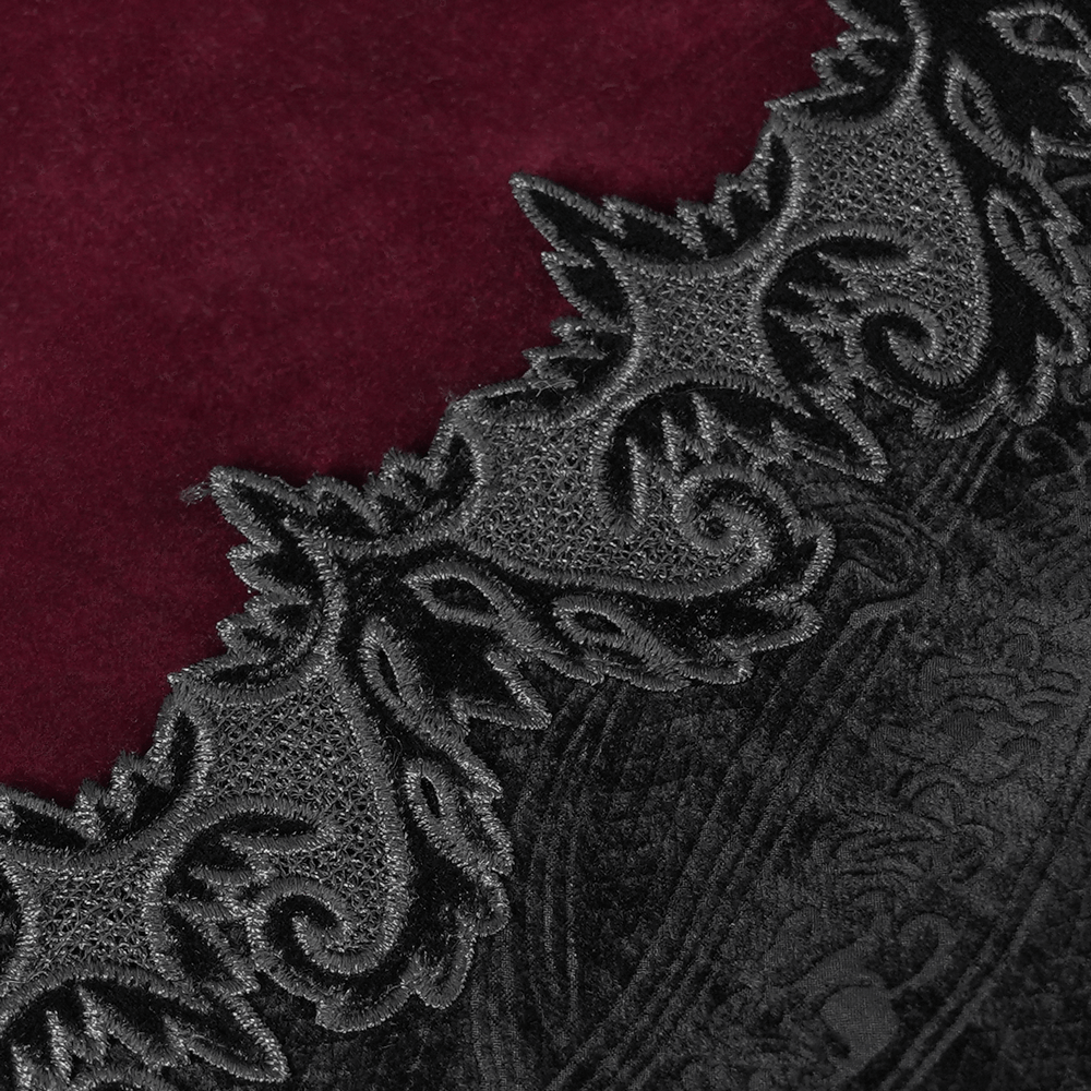Close-up of gothic velvet fabric with wine red and intricate black brocade detailing, perfect for a dramatic attire.