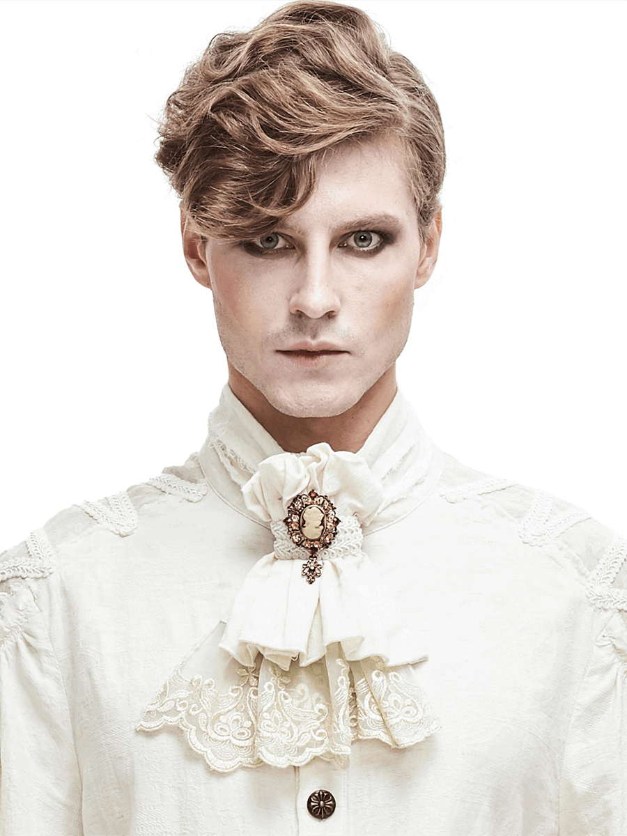 Elegant man in gothic style wearing a white cotton tie with lace and a vintage brooch, showcasing alternative fashion.