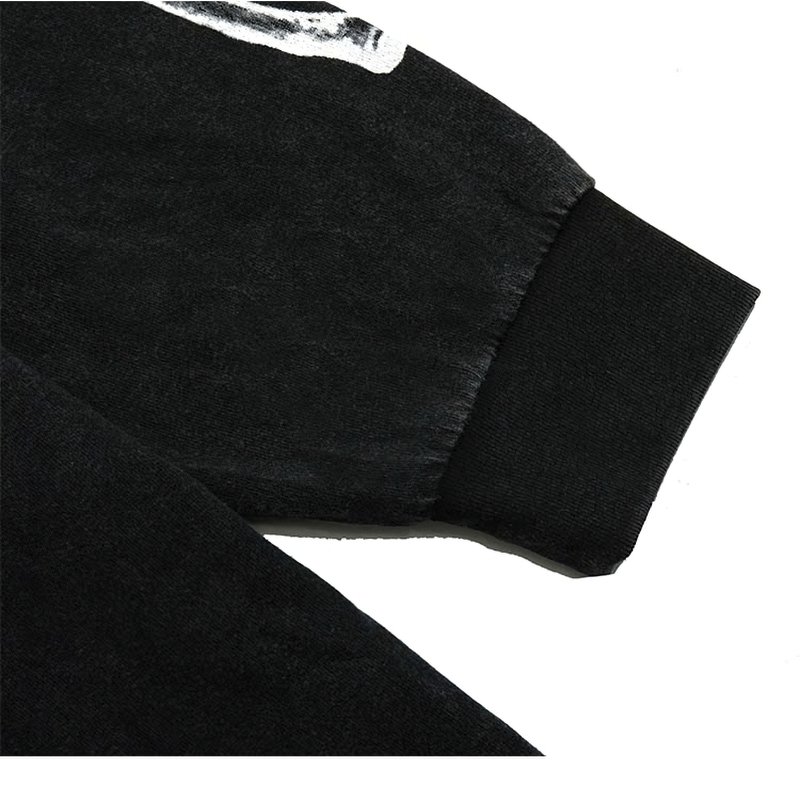 Detail of men's punk style sweatshirt showing black cotton fabric and skeleton print on sleeve.
