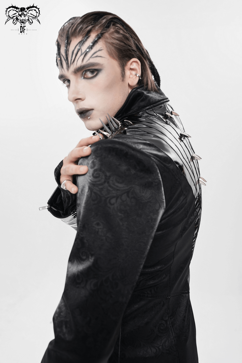 Men's Long Coat with Spikes and Metal Buckle Detail worn by models, showcasing gothic style and sharp shoulder spikes.