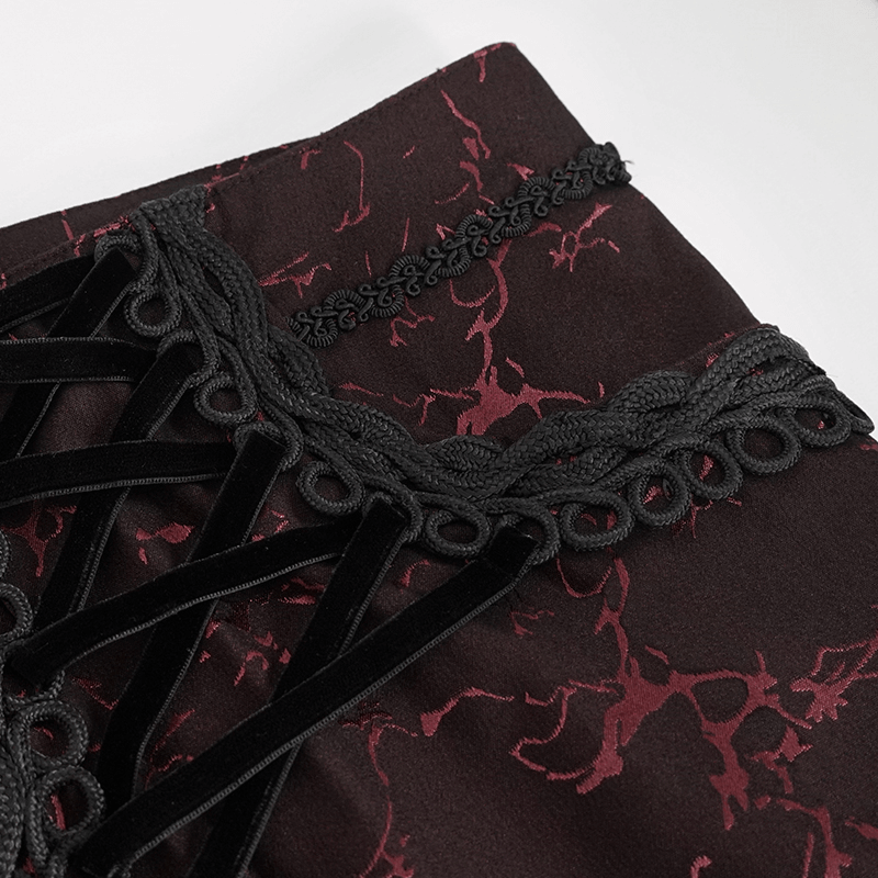 Close-up of lace-up detail on men's red gothic style trousers with vintage pattern.