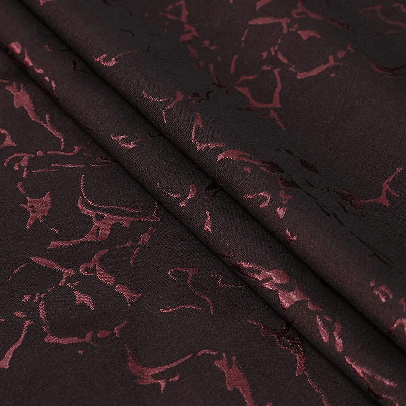 Close-up of fabric with intricate red gothic lace pattern on men's trousers for EU sale, emphasizing vintage style texture.