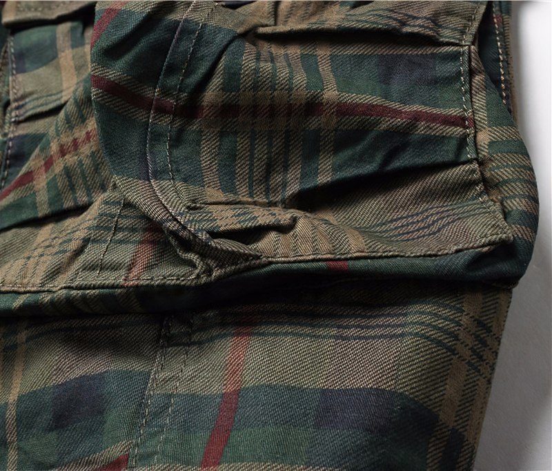 Close-up of men's plaid cargo shorts in earthy tones, showcasing stylish fabric and pockets for a casual look.