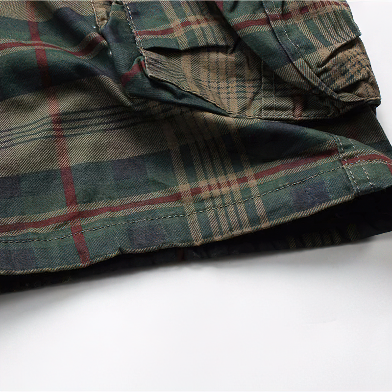 Men's plaid cargo shorts close-up, showcasing stylish green and red pattern for casual military look.