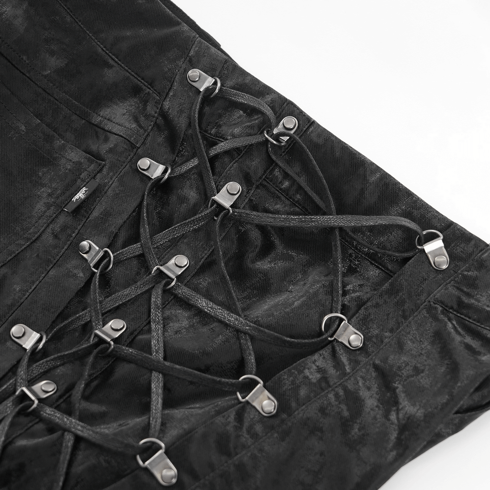 Close-up of lace-up detail with adjustable straps and metallic buckles on men's punk black trousers.