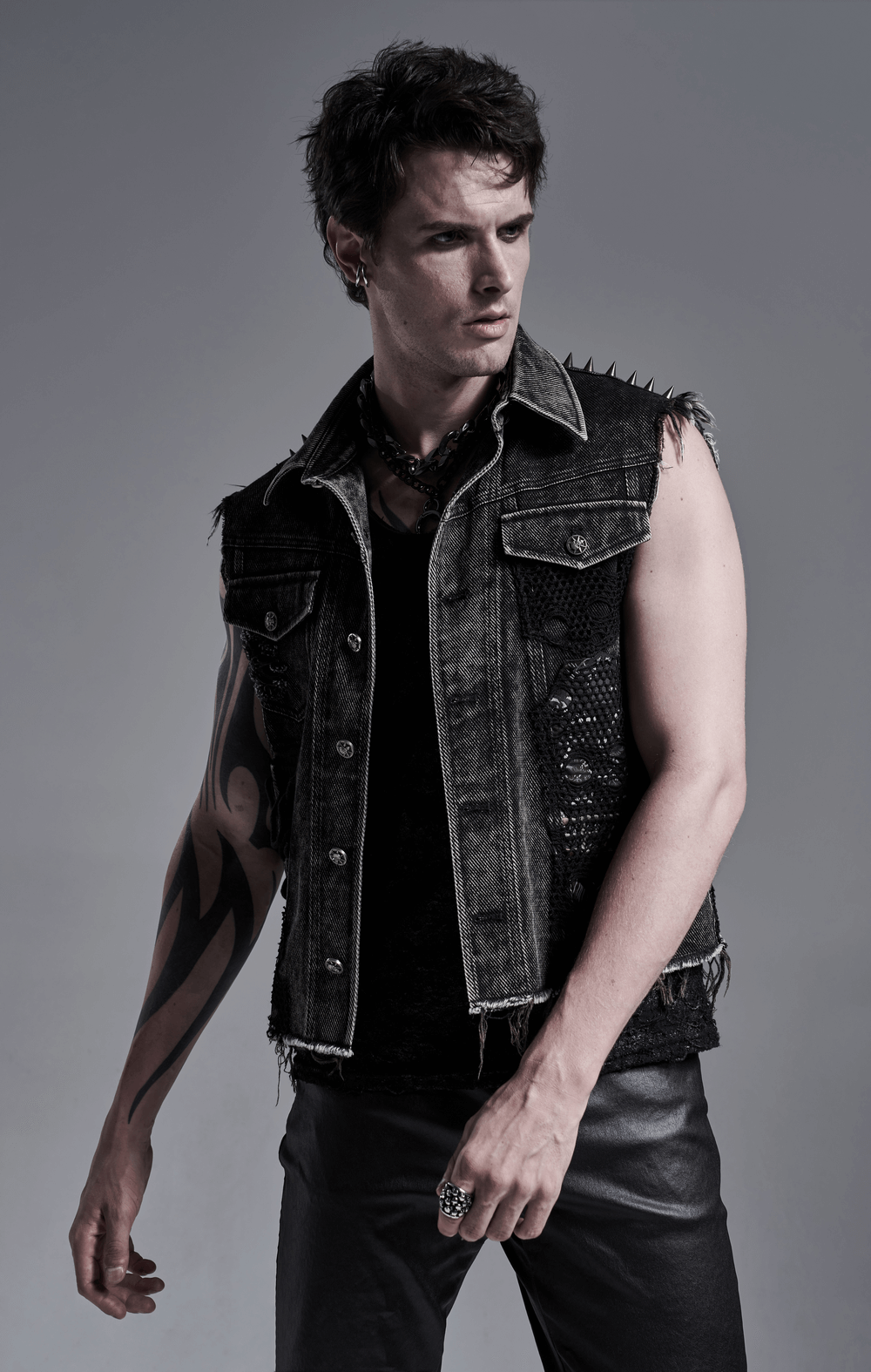 Men's punk denim vest featuring rivets and patches, styled for a rebellious street look.