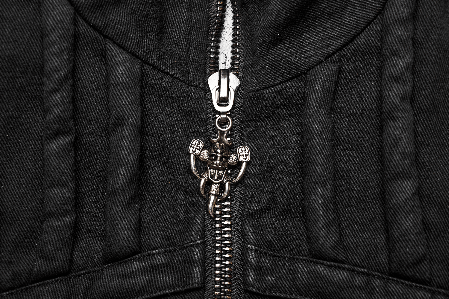 Close-up of a zipper on a black denim vest, showcasing a stylish, edgy design with a unique pull tab.