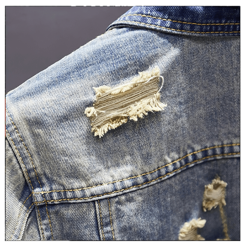 Close-up of a ripped denim patch on a stylish men's vintage jacket, showcasing its unique design.