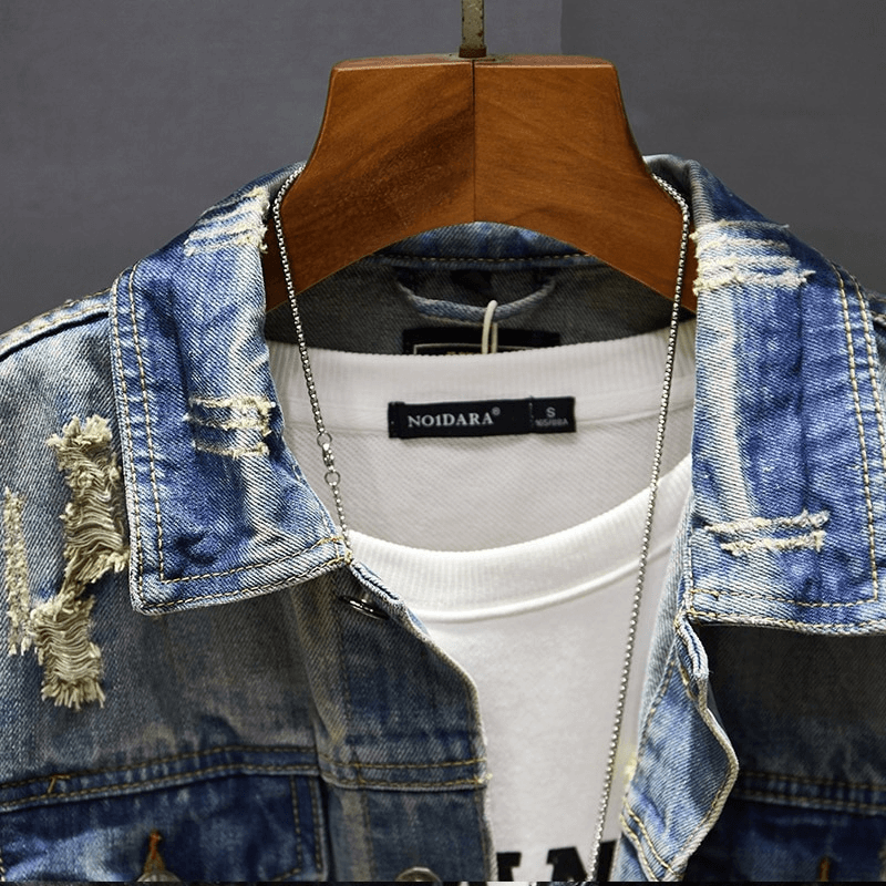Stylish men's ripped denim jacket with vintage design and abrasions, perfect for modern wardrobe.