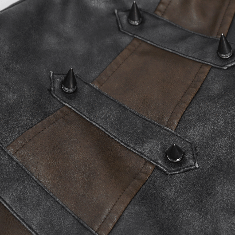 Close-up of men's spiked leather biker vest showing metallic spikes and contrasting brown leather panels.