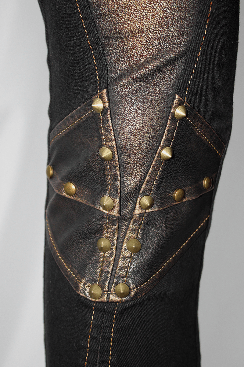 Close-up of men's punk-style tight pants featuring bronze studs and stylish leather patches.