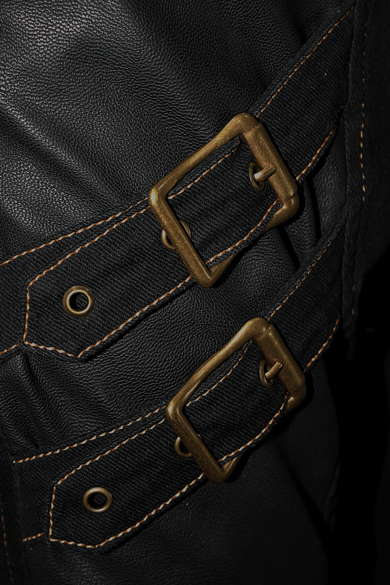 Close-up of bronze buckles and rivets on men's punk-style tight pants for a trendy gothic look.