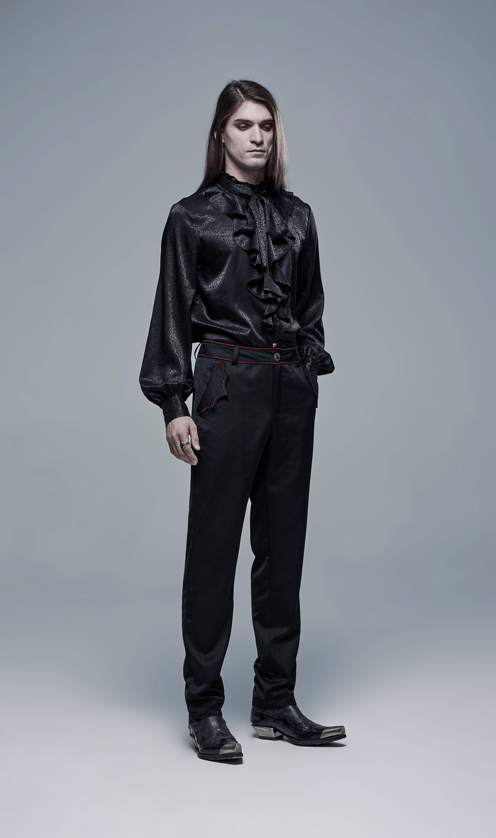 Model in black gothic blouse and tailored trousers with bat embroidery, showcasing dark aesthetic fashion.