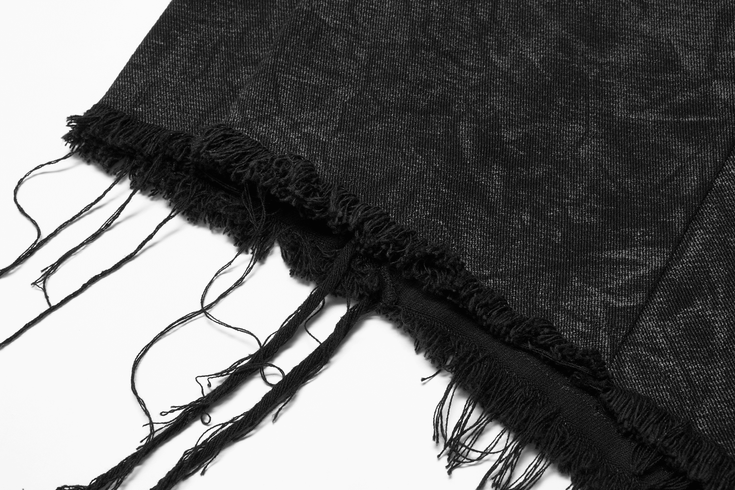 Close-up of the textured black fabric with distressed fringes from a men's gothic kilt.