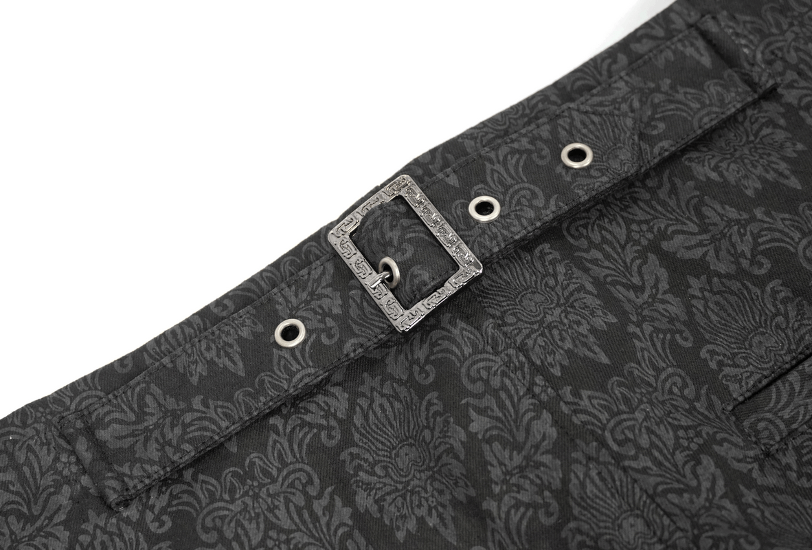 Close-up of men's black vintage pants featuring intricate gothic pattern and decorative buckle.