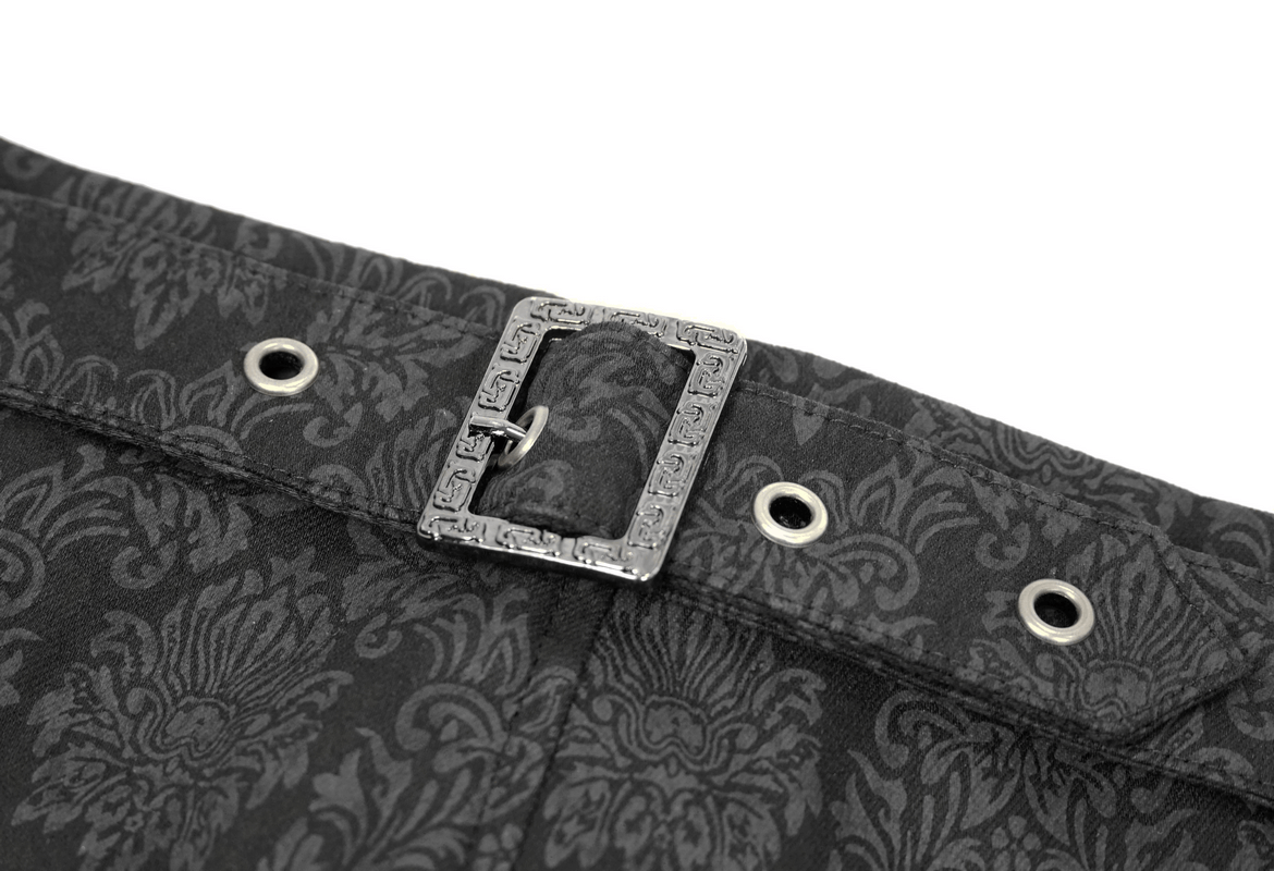 Close-up of vintage black pants showing decorative buckle and gothic print details.