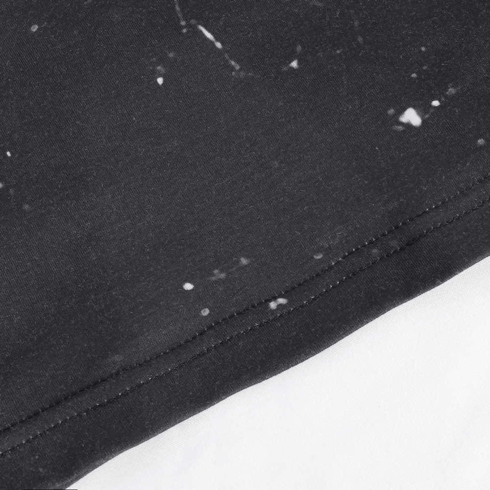 Close-up of the hem of a black mesh crop top with white print details for an edgy alternative fashion look.