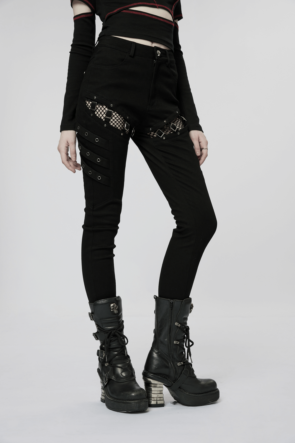 Sleek punk skinny pants with mesh detail and zigzag buckles, paired with edgy black combat boots.