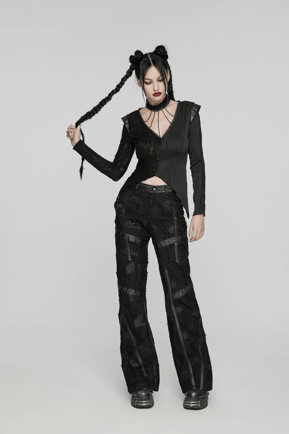 Model showcasing edgy black mesh twill denim straight pants with leather accents and stylish top.