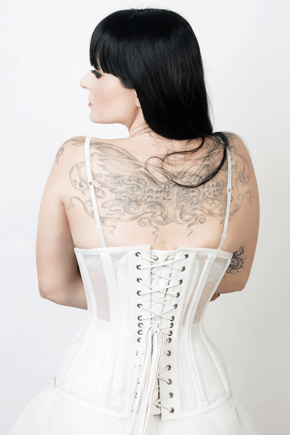 Model showcasing a white mesh waist training corset with steel boning and back lacing, highlighting its stylish design.