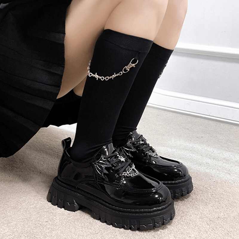 Gothic bat wing platform shoes with chunky soles and metal chain detail, perfect for edgy style enthusiasts.
