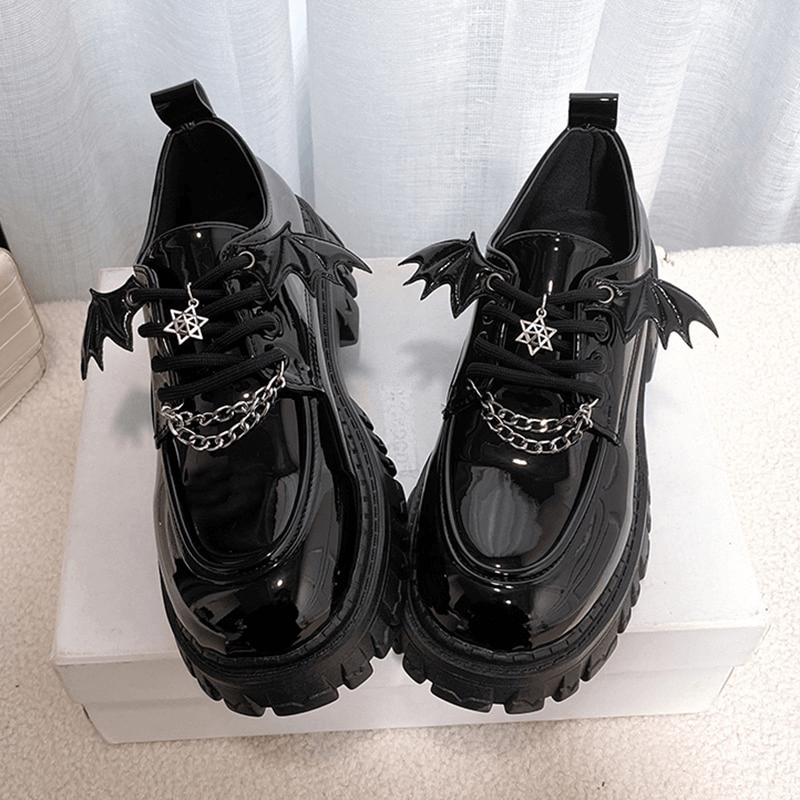Metal chain bat wings chunky platform shoes in glossy black patent leather for gothic style.