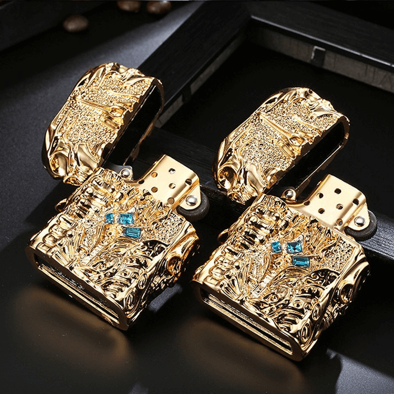 Gold metal lighter with intricate design and blue gemstones, perfect for stylish accessory lovers.