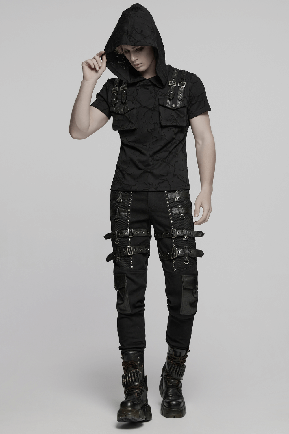 Model wearing metal punk stretch pants with buckles and a hooded shirt, showcasing edgy fashion style.