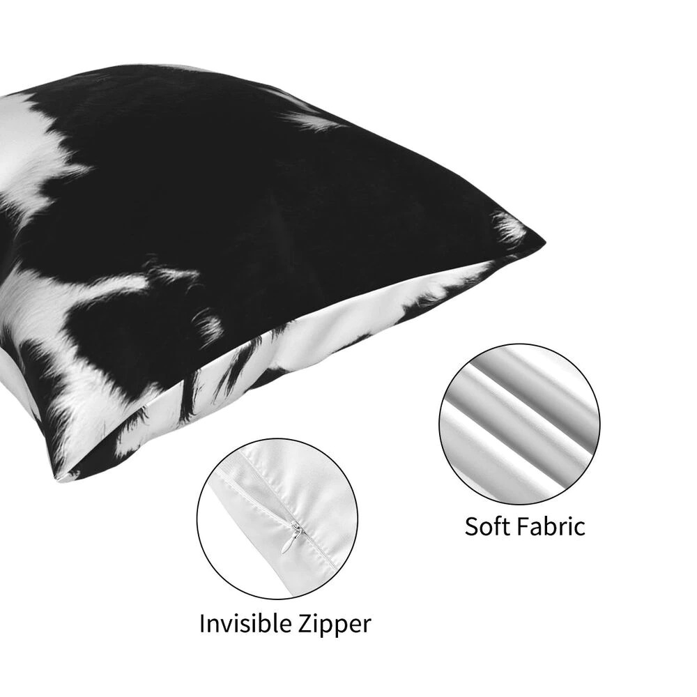 Close-up of a black and white modern cowhide pillow showcasing soft fabric and invisible zipper for home decor.
