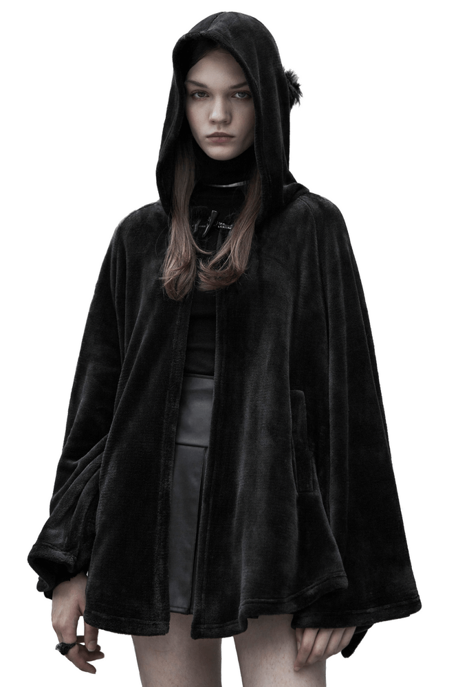 Model wearing a dark velvet hooded cloak jacket for a gothic-inspired look.