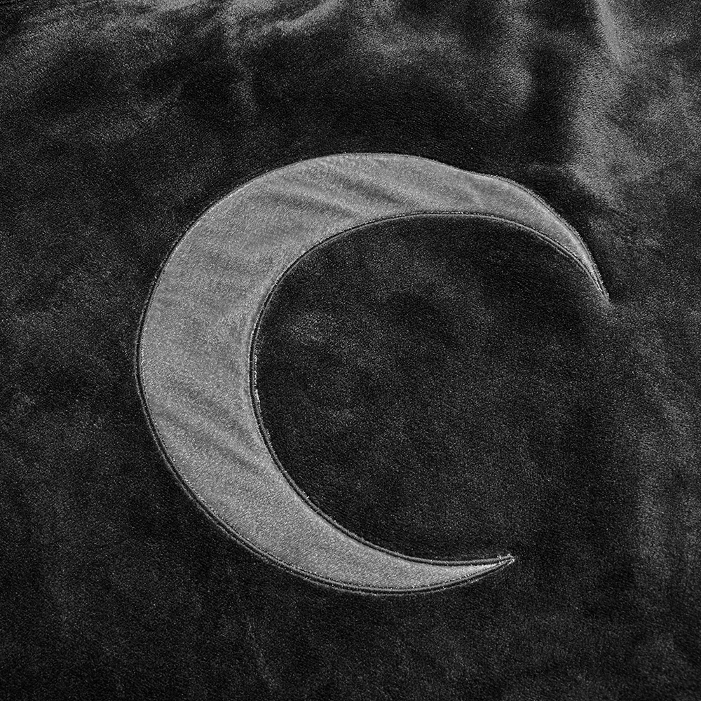 Embroidered crescent moon detail on dark velvet fabric of a cloak jacket.