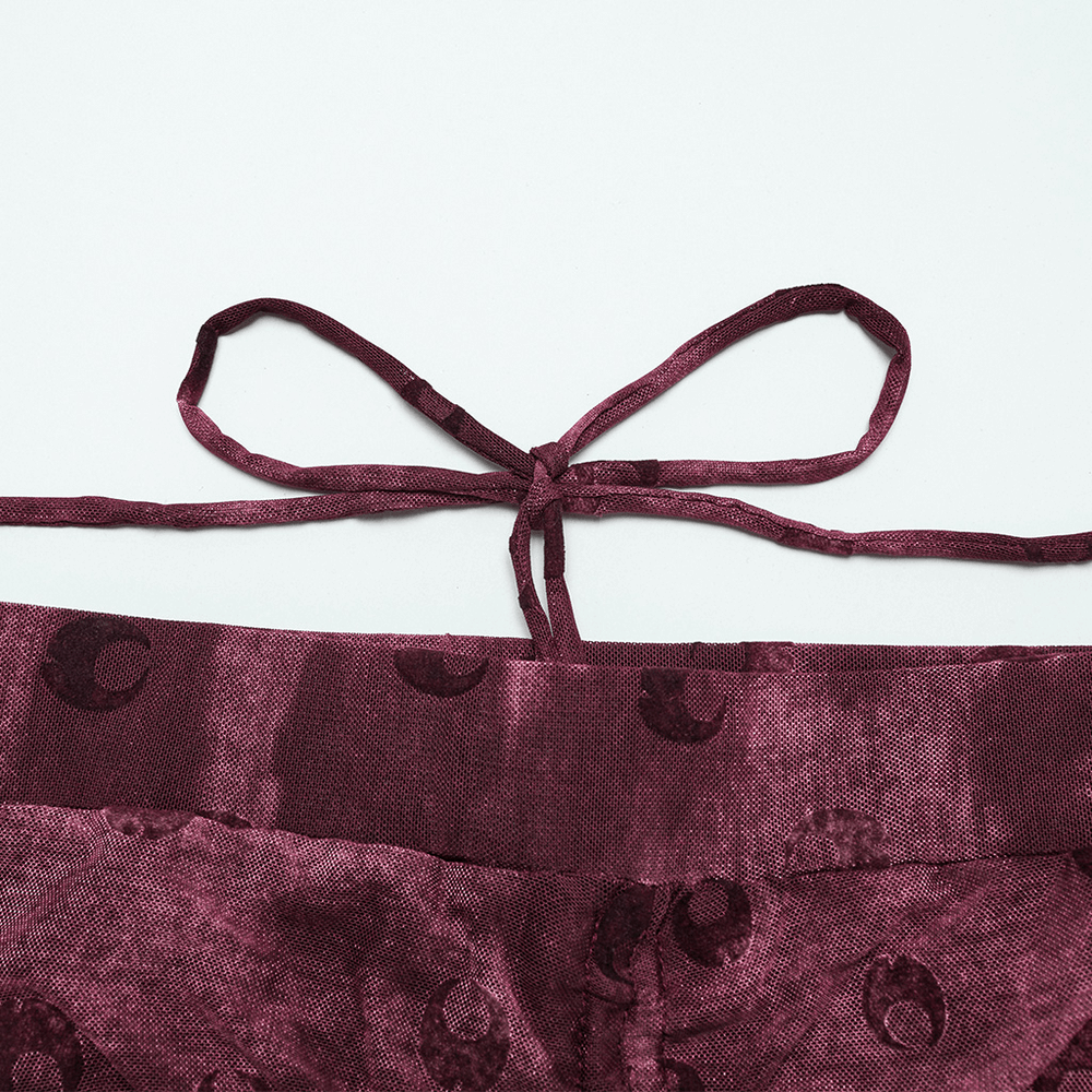 Close-up of moon printed mesh flare pants showing crescent embroidery and tie detail at the back.