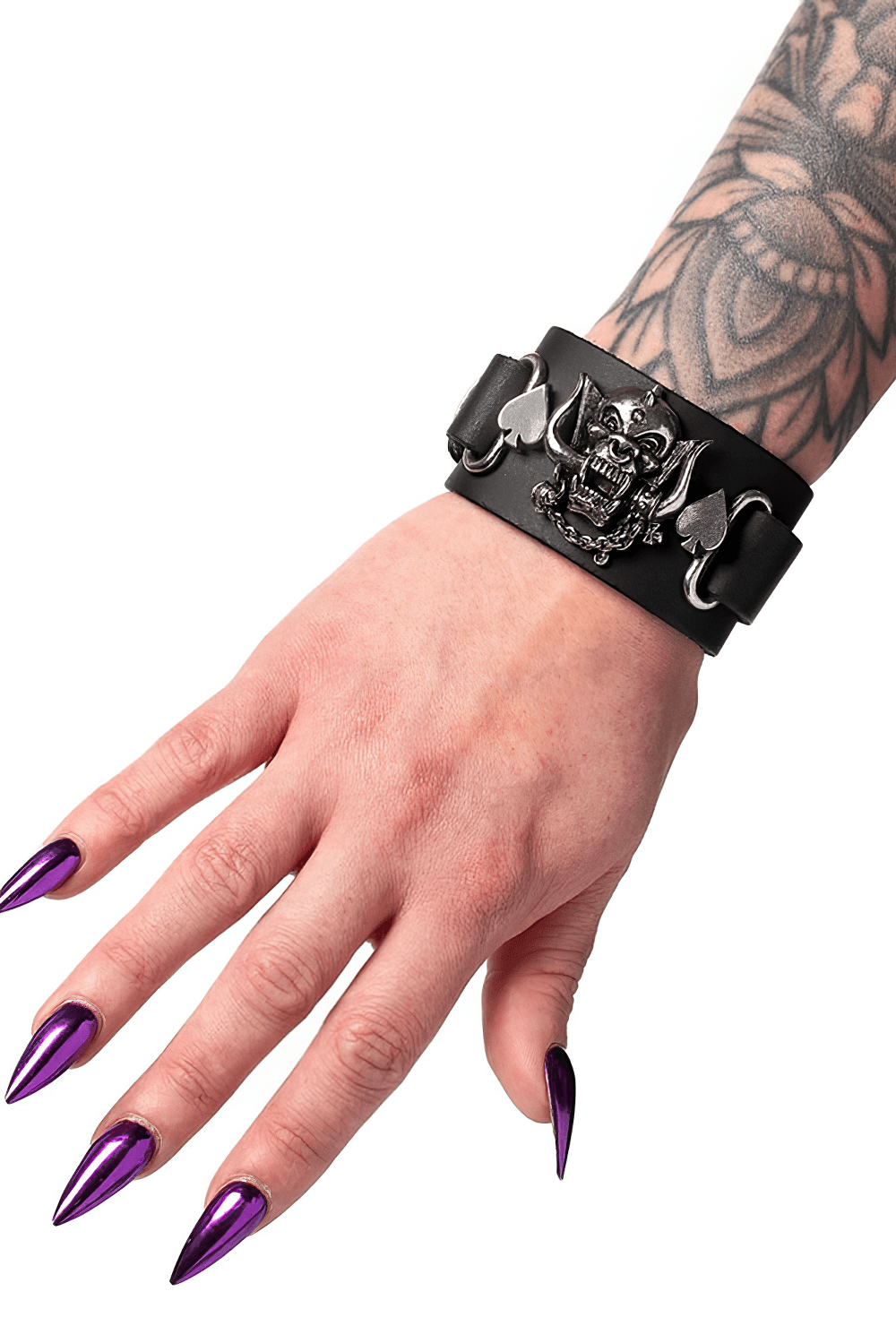 Motörhead Warpig leather bracelet with spade accents, bold design on a tattooed wrist and striking purple nails.