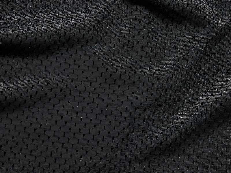 Close-up of black perforated fabric, showcasing a stylish texture perfect for motorcycle vests.