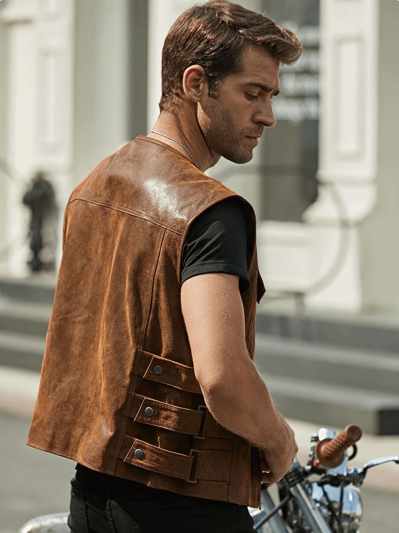 Stylish man in brown leather vest riding a motorcycle, showcasing edgy punk fashion and rugged charm.