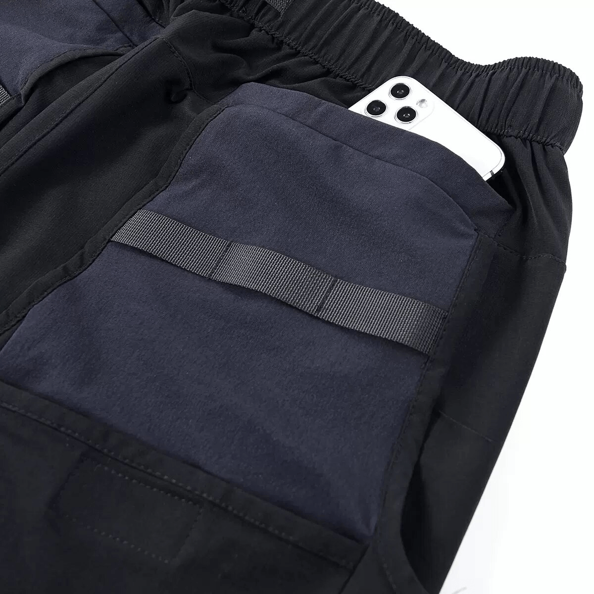 Close-up of multi-pocket tactical cargo shorts with a phone in the pocket, showcasing stylish design and comfort.