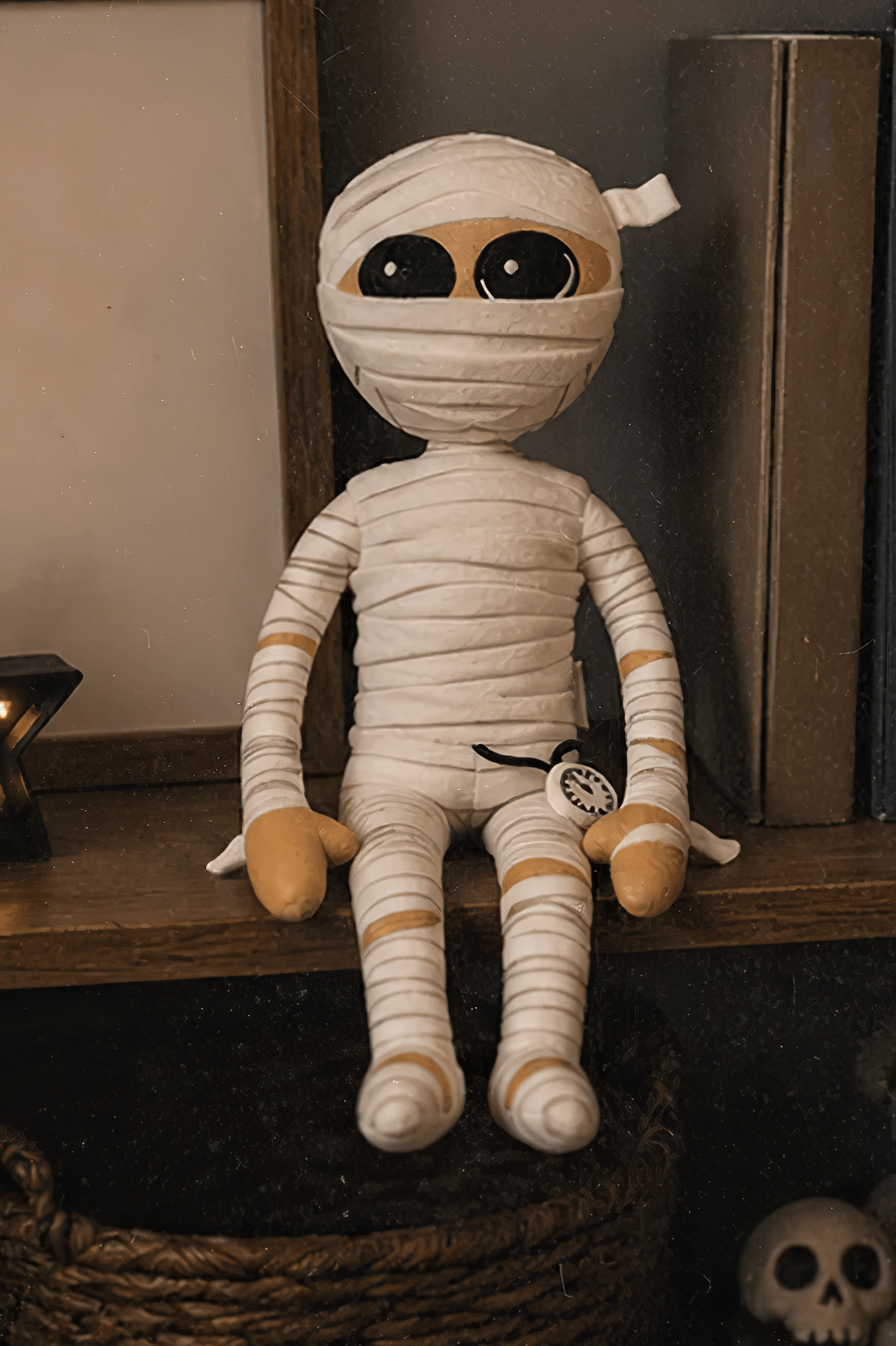 Mummington Mummy Plush Doll with Glow in the Dark Watch sitting on a shelf, perfect Halloween decor.