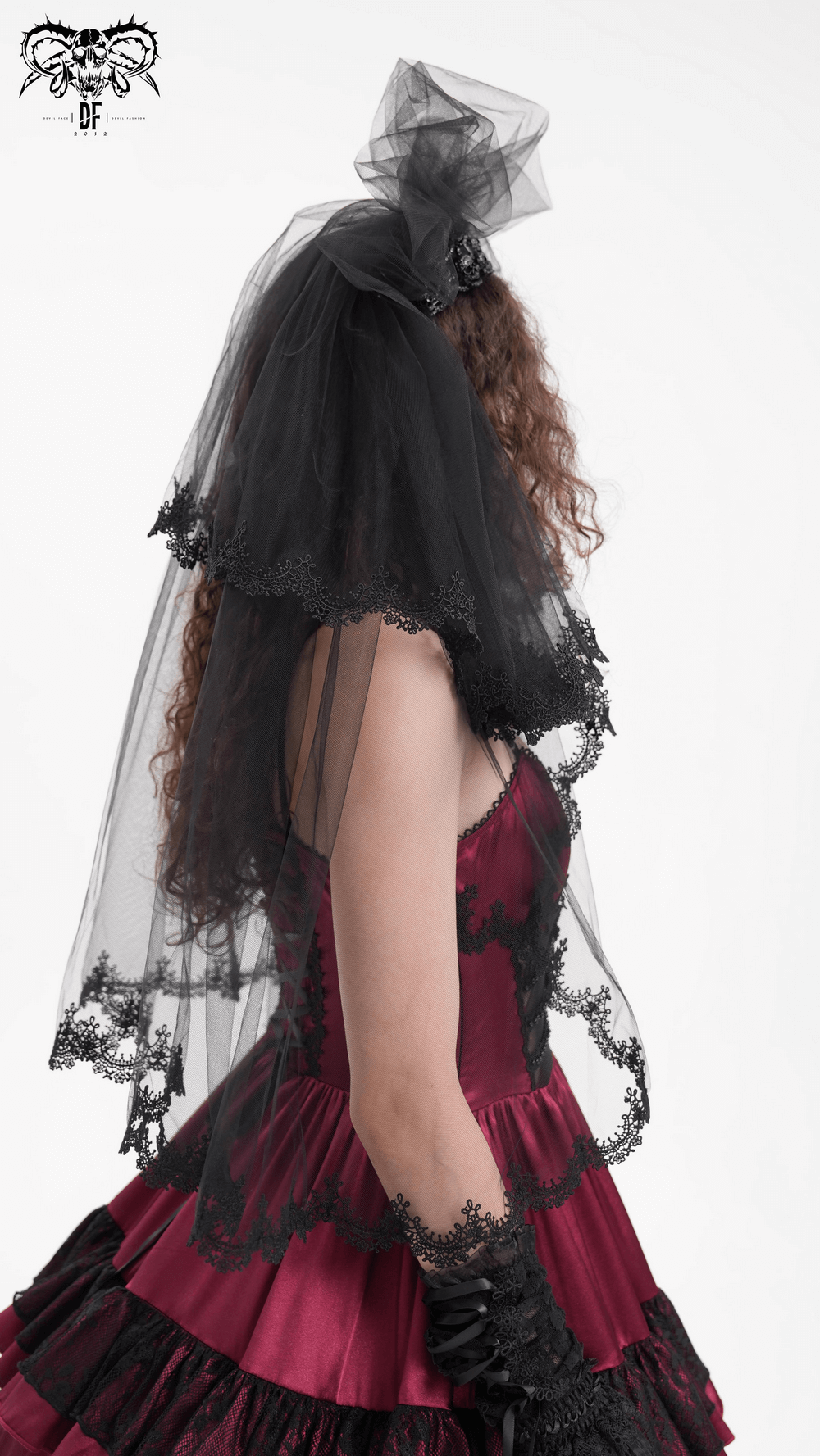 Elegant black lace bridal veil draping over shoulder of a woman in a red dress, perfect for a chic wedding look.