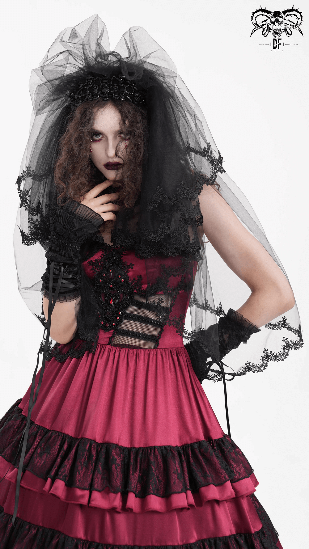 Gothic bride in a dramatic black lace veil and red dress, showcasing an elegant and mysterious wedding look.