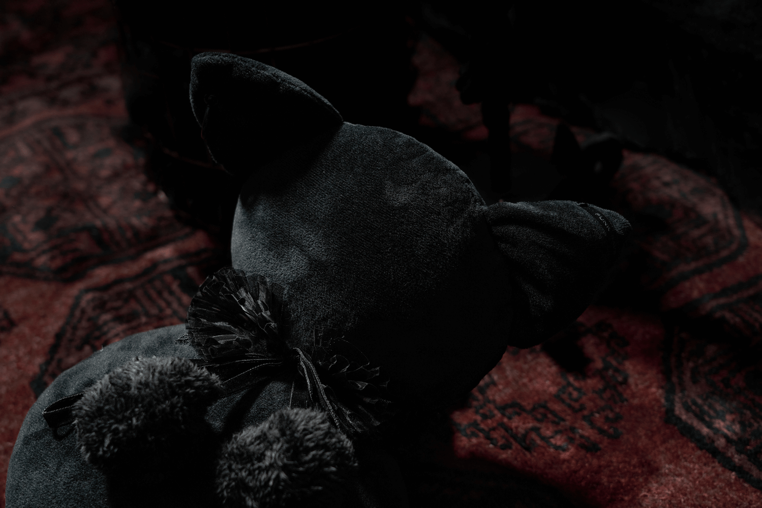 Enchanted black faceless cat plush with hearts on a vintage rug, embodying gothic Halloween decor.