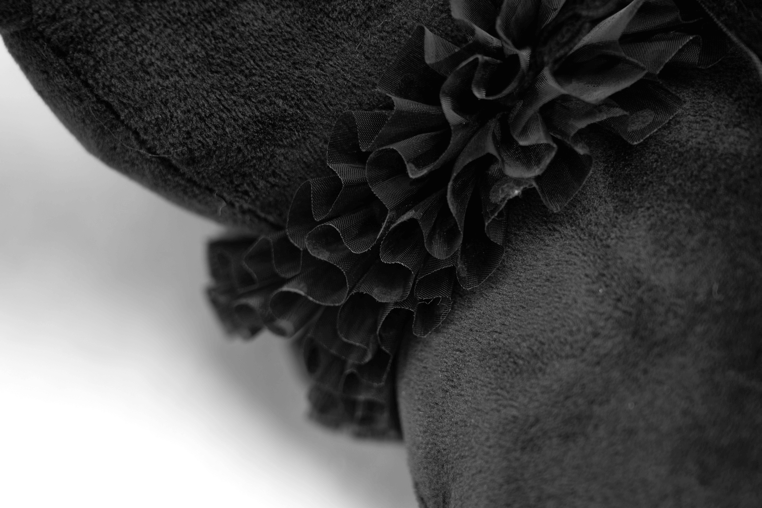 Close-up of soft black fabric with elegant ruffled detailing, perfect for gothic plush decor.